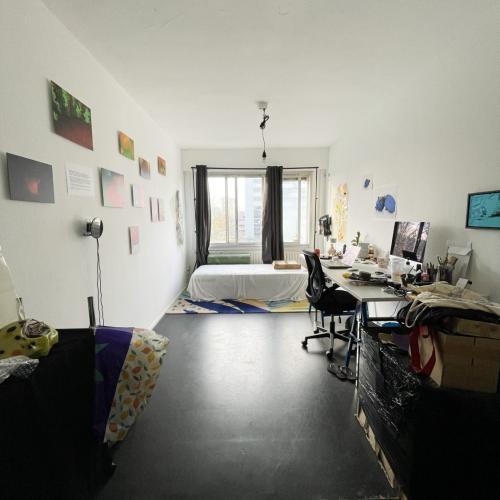 Groot, licht ingericht slaapkamer met wit beddengoed en kunst aan de muur.
