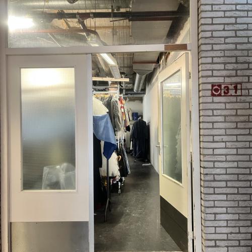 Gevel van een winkel met een ingang en een stoffig, industriële uitstraling.