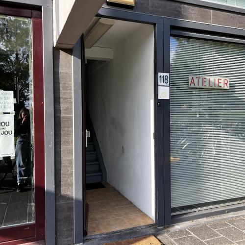 Gevel van een winkelpand, met een vitrine links en een gesloten winkelpui rechts met het woord 'ATELIER'.
