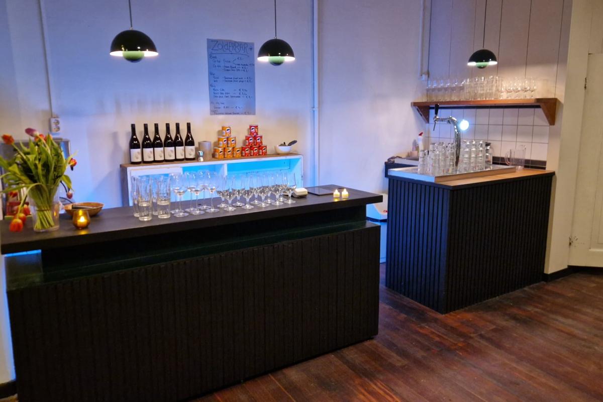 Twee moderne bars in een lounge, met flessen, glaswerk en sfeerverlichting.