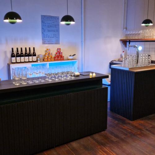 Twee moderne bars in een lounge, met flessen, glaswerk en sfeerverlichting.