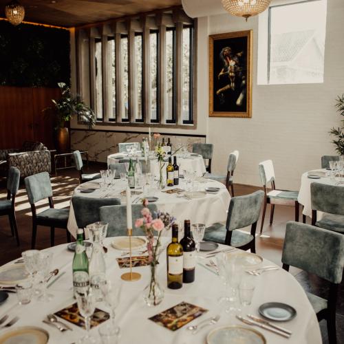 Elegant restaurantinterieur met een gedekt ronde tafel, bestaande uit wit linnen en kleding.
