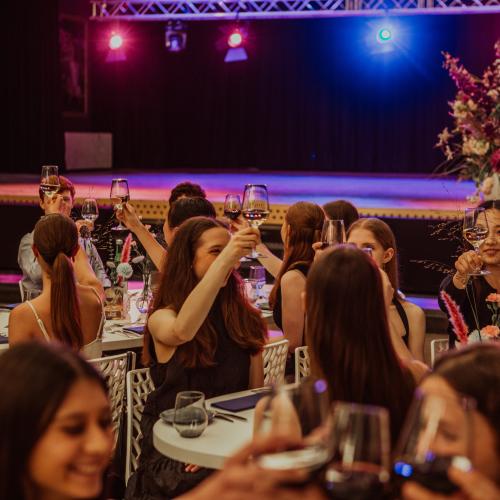 Groep vrouwen die op een feestje of evenement samenkomen, in een levendige setting.