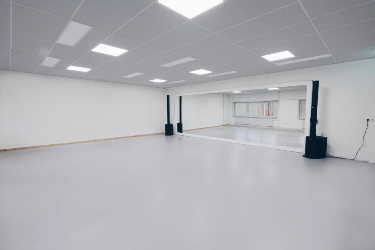 Leeg, modern kunstgalerie met witte muren en witte vloer, voorzien van enkele zwarte luidsprekers.