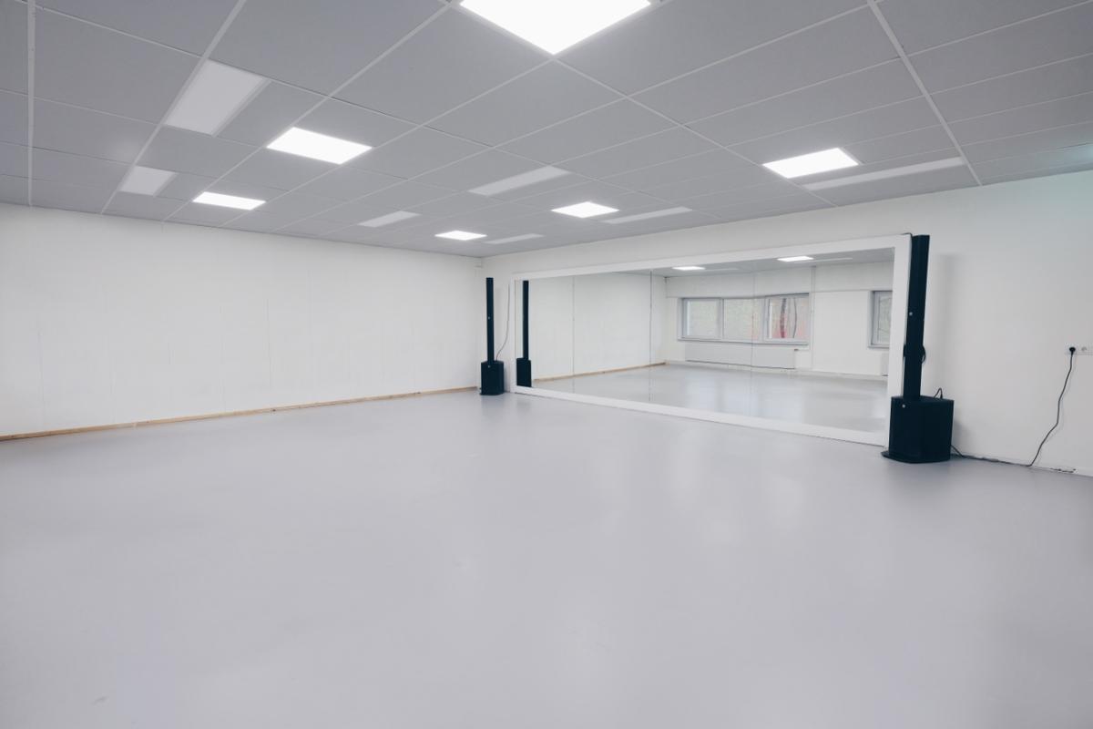 Leeg, modern kunstgalerie met witte muren en witte vloer, voorzien van enkele zwarte luidsprekers.