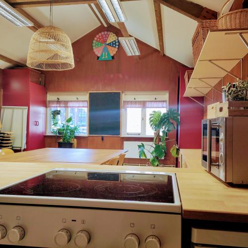 Keukeninterieur met een fornuis en aanrechtblad, keukenblok en raam onder een schuin, A-frame plafond.