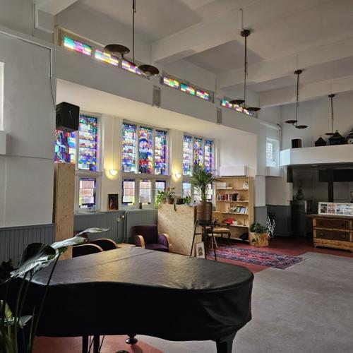 Interieur van een kerk: kleurrijke glas-in-loodramen, een ceremonieel bed en een grote ruimte.